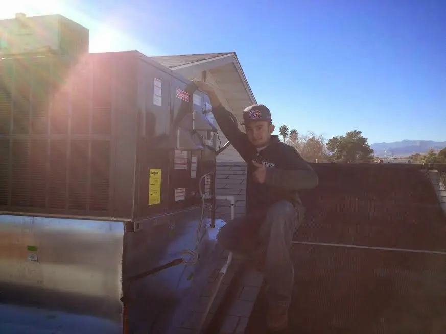 HVAC technician performing HVAC Inspection on a rooftop unit in Lansdowne